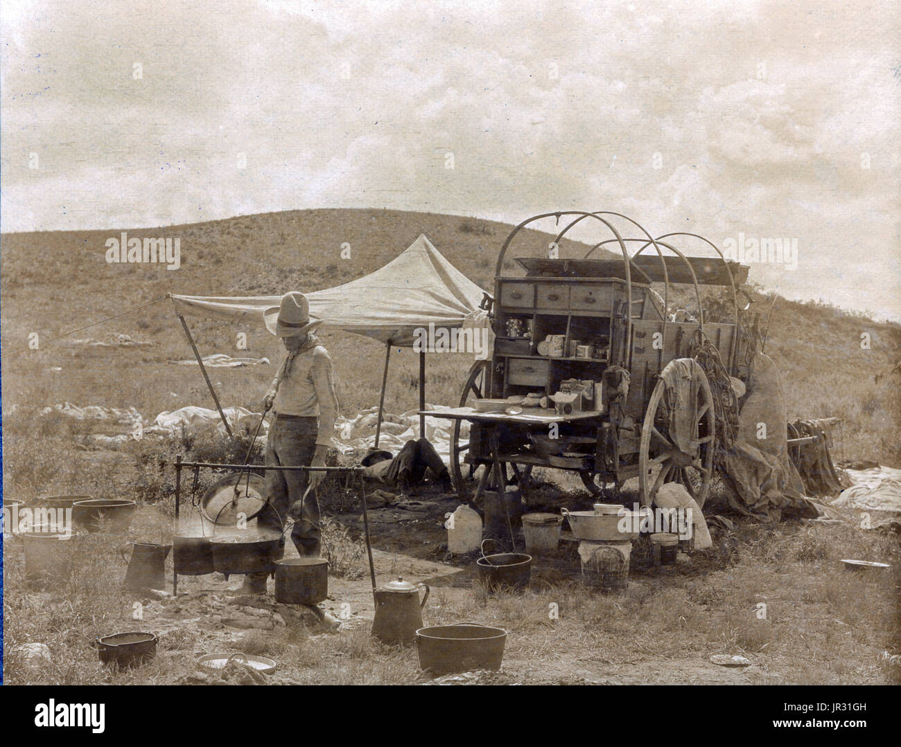 Le chuckwagon est attribuée à Charles Goodnight, un éleveur du Texas, qui a introduit le concept en 1866. Éleveurs de bovins parqués dans des régions du pays qui n'ont pas de chemins de fer, ce qui signifiait qu'ils avaient besoin d'être nourris sur la route pendant des mois à la fois. Bonne nuit modifié le wagon Studebaker, un surplus de l'armée durable-wagon, ajouté un 'chuck' à l'arrière du chariot avec tiroirs et étagères pour l'espace de stockage et un couvercle à charnière pour fournir une surface de cuisson. Un baril d'eau était également joint à la familiale et la toile était suspendu en dessous pour transporter du bois de chauffage. Un wagon box a été utilisé pour stocker la cuisson supplie Banque D'Images