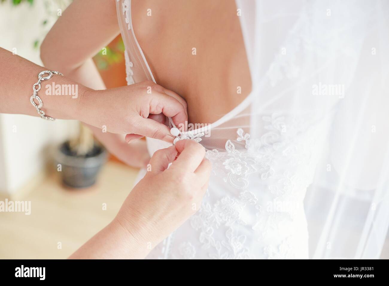 Mère de la mariée - aider sa fille de mettre sa robe de mariage, sur la photo en gros Banque D'Images