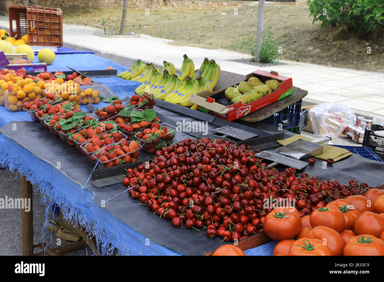 Vouliagmeni Grèce Saturday Market Stall avec les tomates, les cerises, fraises, bananes, abricots et poires Banque D'Images