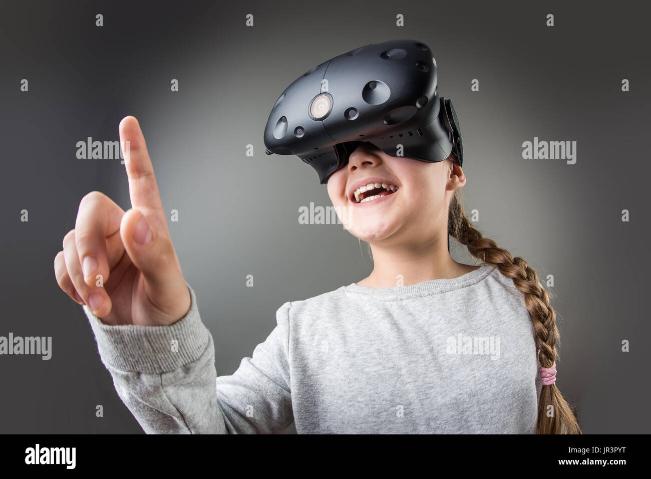 Surpris petite fille à l'aide d'un casque de réalité virtuelle Banque D'Images
