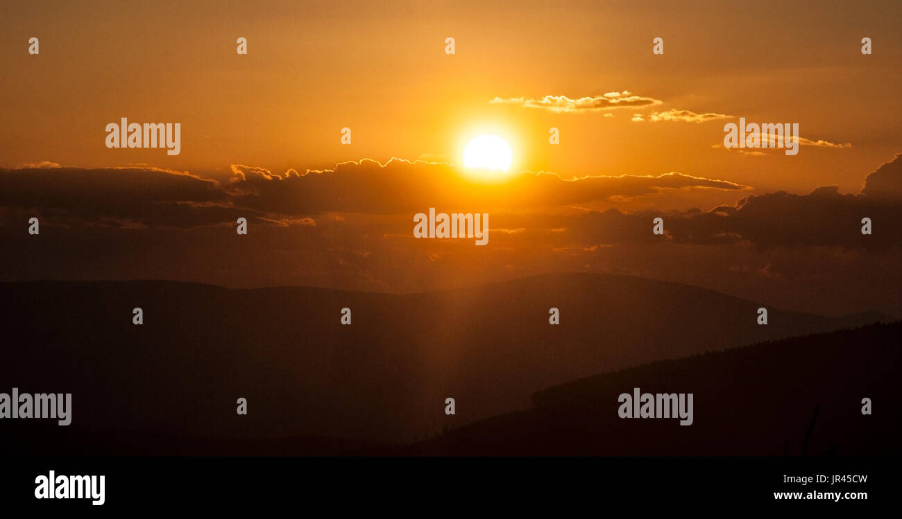 Coucher du soleil sur la colline au-dessus de hrbet Jeleni Jeleni studanka dans Jeseniky mountains en République tchèque, avec des collines, ciel coloré, sun avec sunlights et nuages Banque D'Images