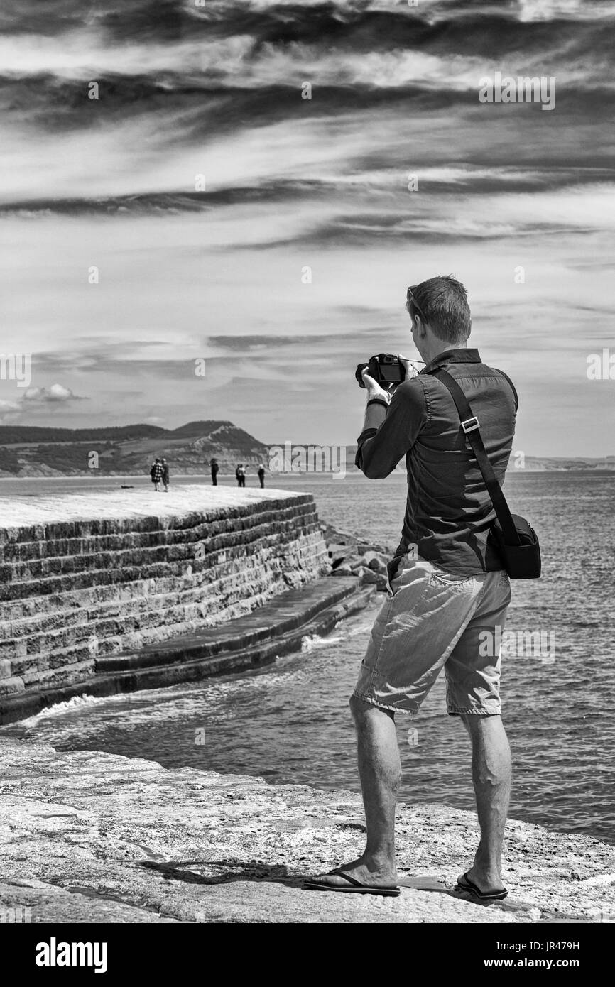 Photographe homme photos photographies de visiteurs sur le Cobb à Lyme Regis, dans le Dorset en Juillet Banque D'Images