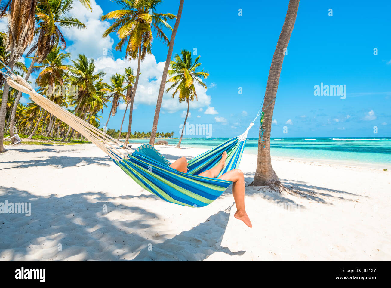 Canto de la Playa, l'île de Saona, à l'Est Parc National (Parque Nacional del Este), la République dominicaine, la mer des Caraïbes. Femme de vous détendre sur un hamac. Banque D'Images
