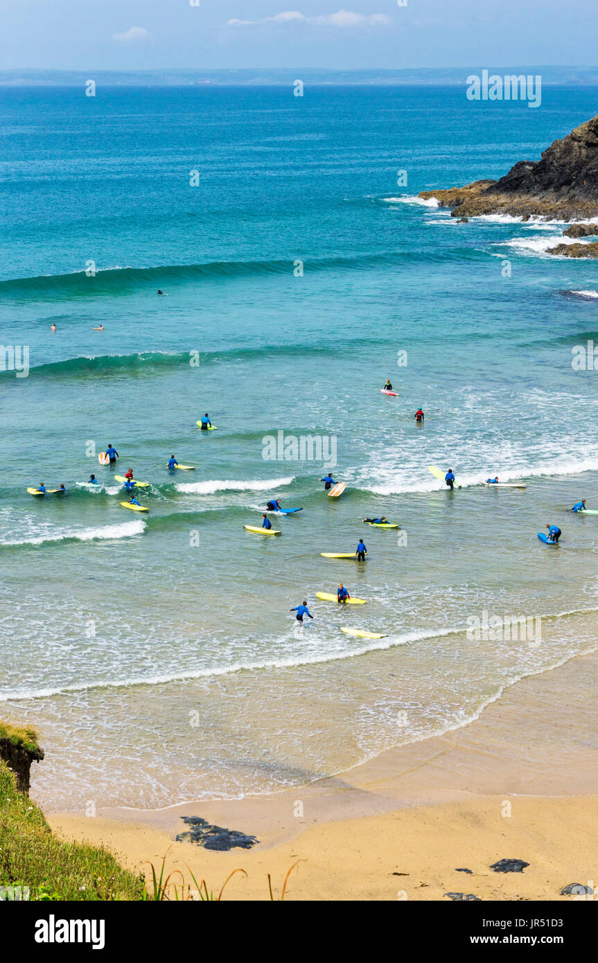 L'école de surf avec les gens apprendre à surfer à Poldhu Cove beach, Cornwall, UK Banque D'Images