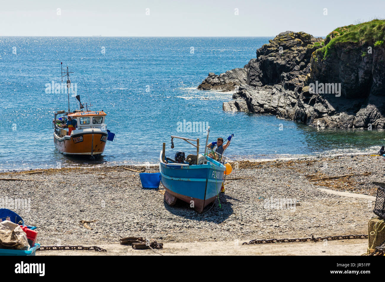 Pêcheur et bateau de pêche à Cadgwith Cove, Lizard Peninsula, Cornouailles, Royaume-Uni Banque D'Images