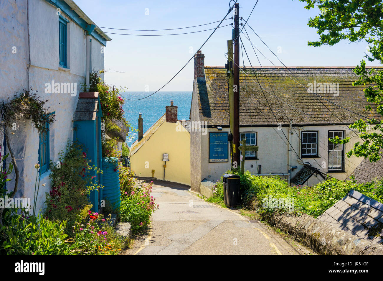 Village UK street à Cadgwith, Cornwall, UK sur la Péninsule du Lézard en été avec la mer derrière Banque D'Images