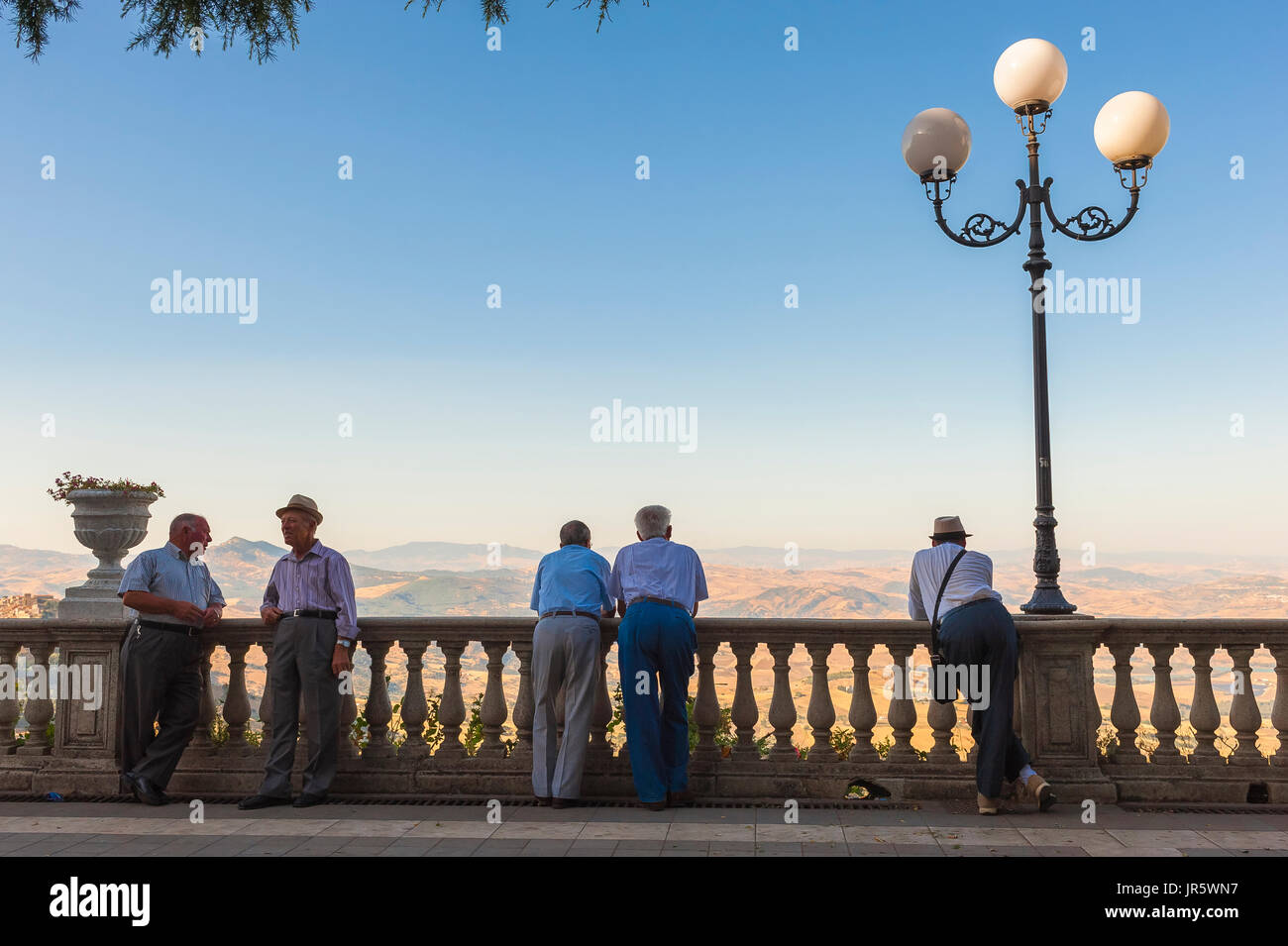 Sicile hommes, vue d'un groupe d'hommes siciliens de haut niveau dans la Viale G. Marconi à Enna chatter et regarder le soleil descendre sur les collines voisines. Banque D'Images