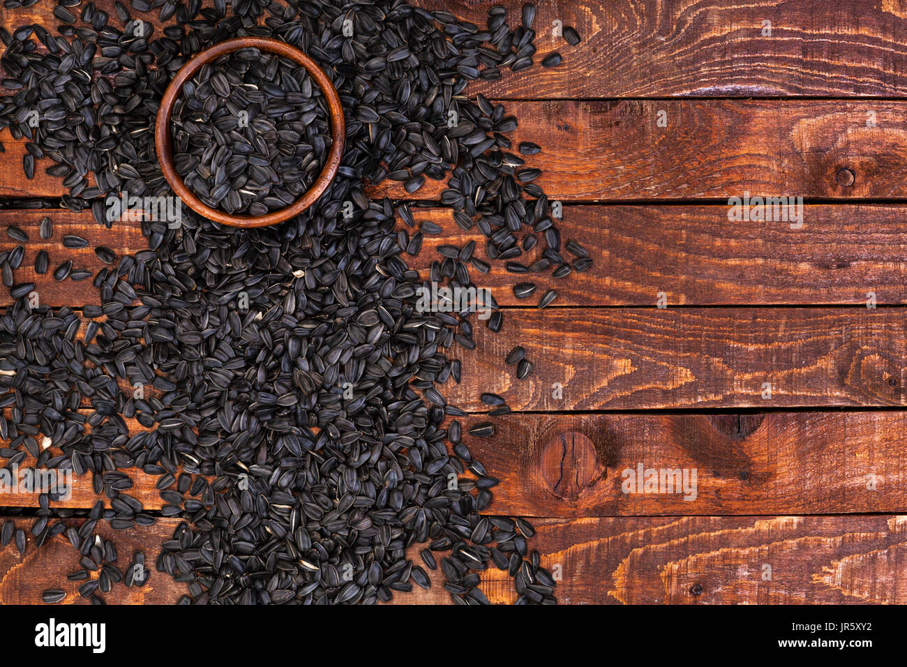 Les graines de tournesol noires sur fond de bois, vue du dessus, copy space Banque D'Images