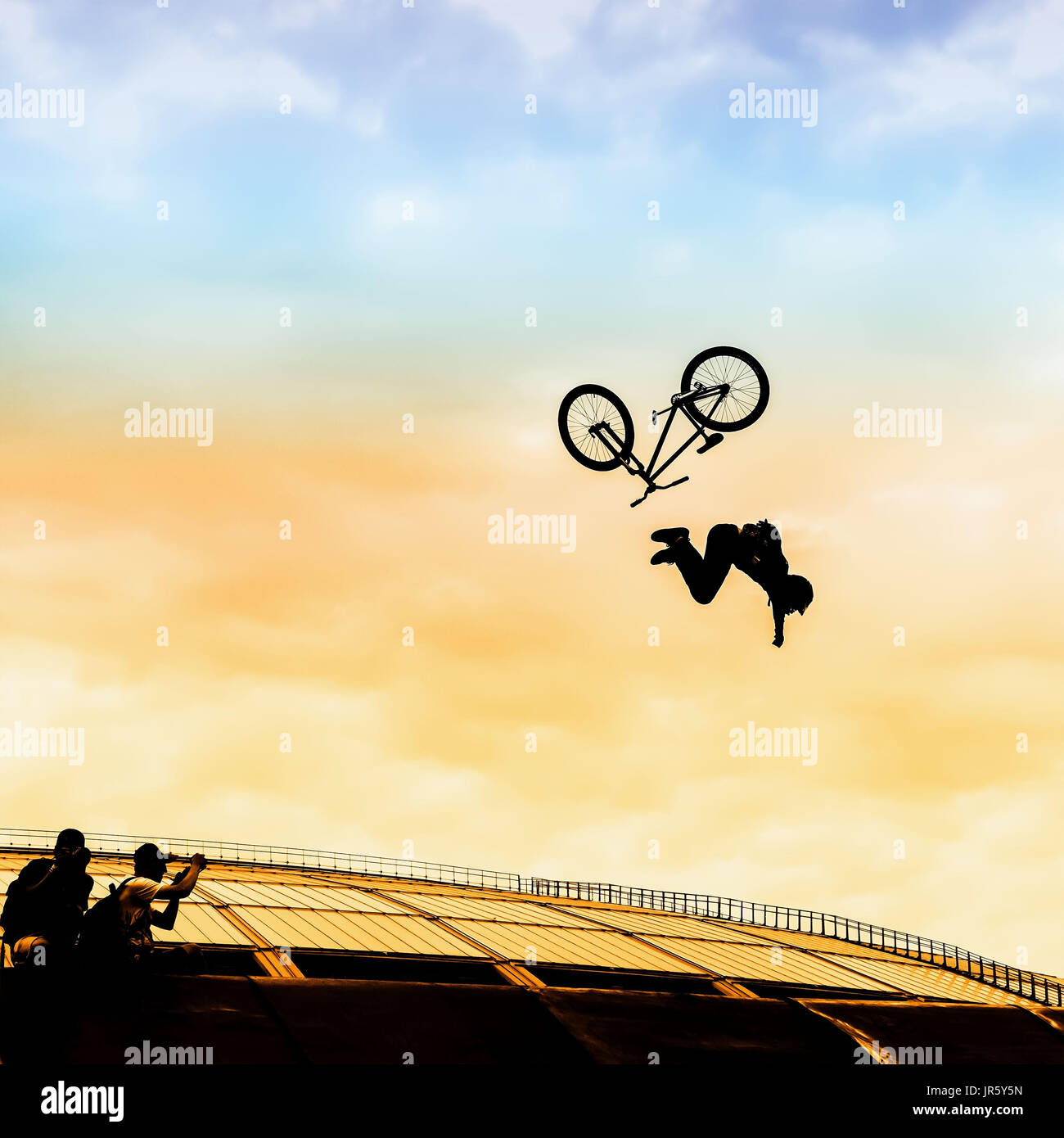 Extrême. Silhouette d'un jeune homme faisant un saut avec un vélo BMX sur le fond de ciel clair. Moment risqué de tomber entre dans les cadres de Banque D'Images