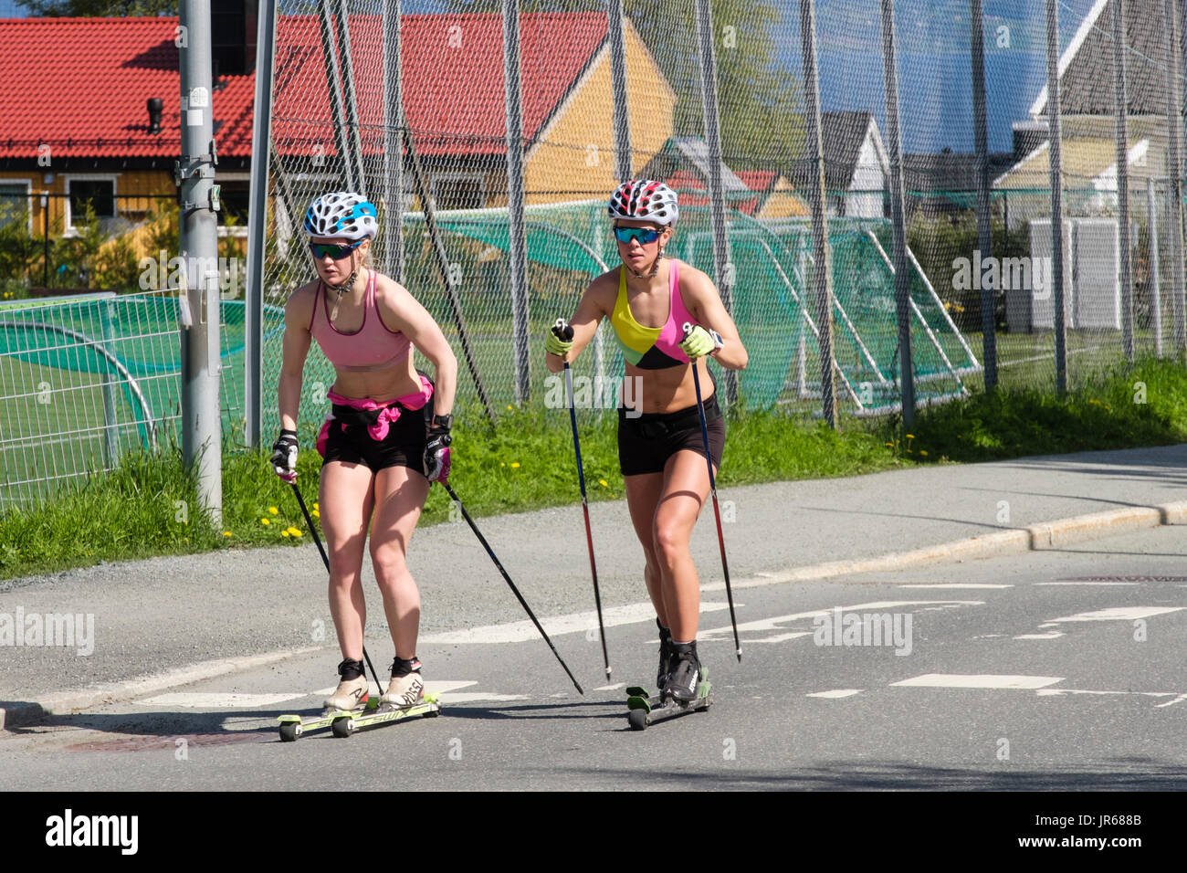Deux femmes sur skis à roulettes rollerskiing nordique sur une route en été. Norvégien typique de vie actif. Trondheim, Sør-Trøndelag, Norvège, Scandinavie Banque D'Images