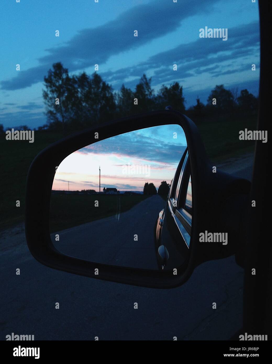 Coucher du soleil dans un miroir de voiture Banque D'Images