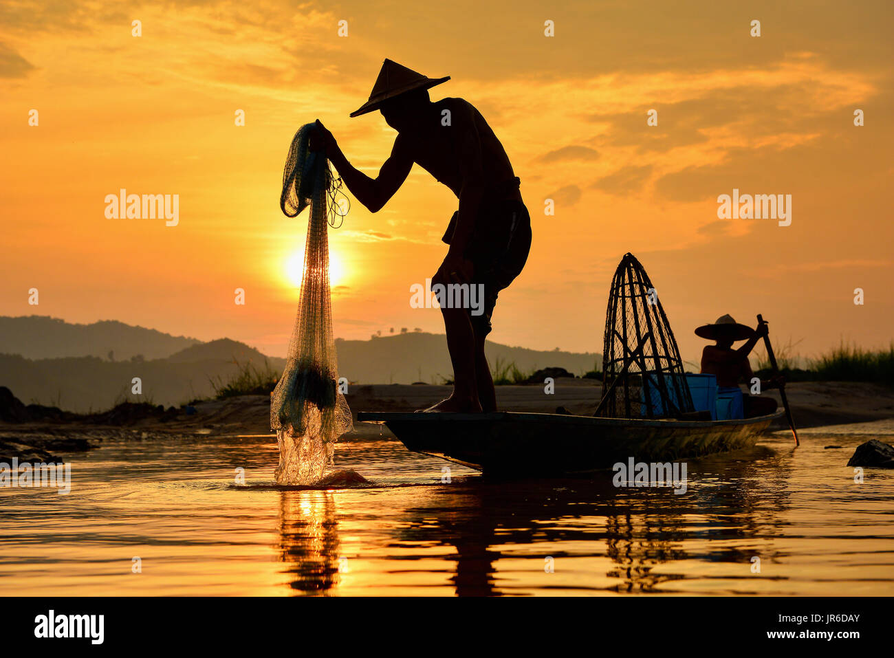 Silhouette de levage filet de pêche Les pêcheurs de la rivière au coucher du soleil, la Thaïlande Banque D'Images