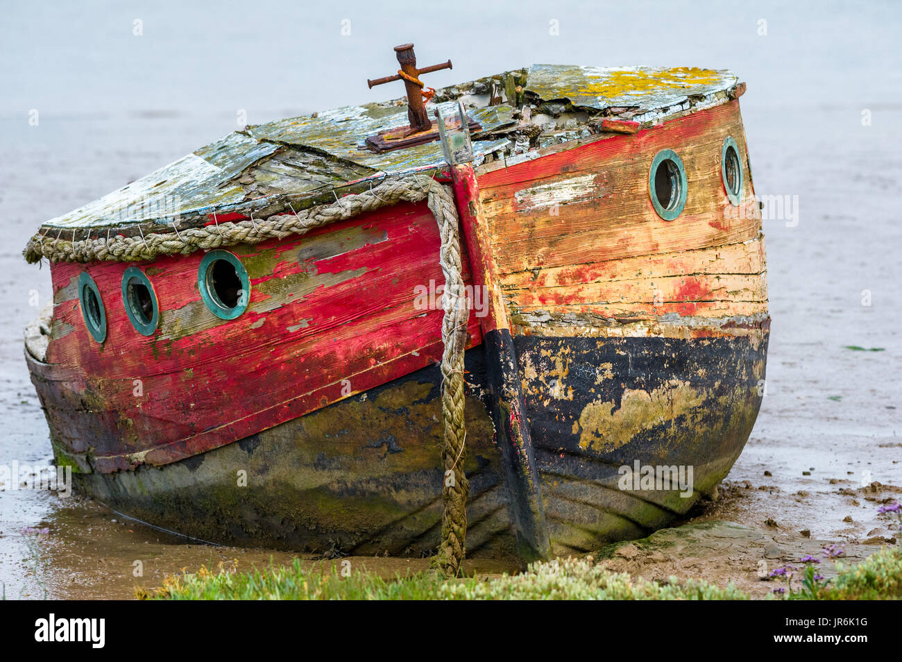 Les bateaux en bois en décomposition échoués dans l'estuaire boueux à Orford, Suffolk. Banque D'Images