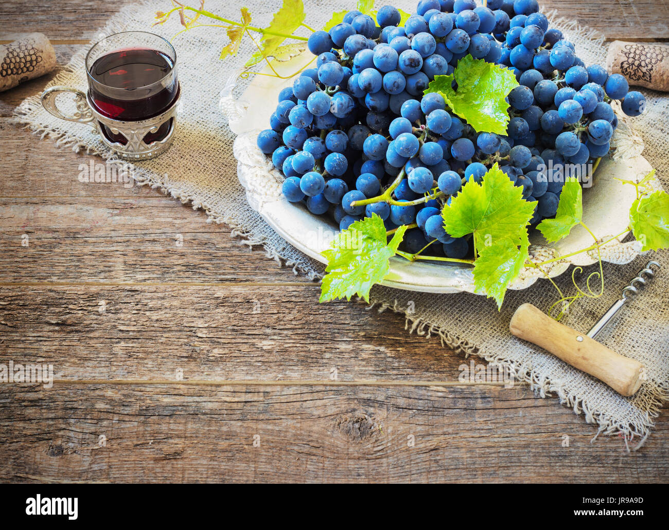Le vin rouge et les raisins. Vin et raisin dans réglage vintage avec des bouchons sur table en bois Banque D'Images