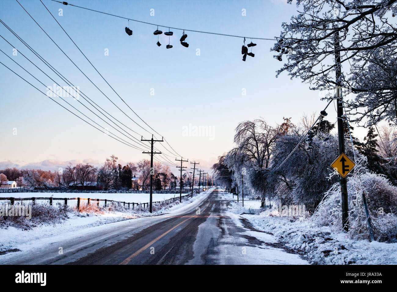 Chaussures congelé sur une ligne sont couvert de glace de une tempête de glace. Ce paisible route de campagne montre une scène d'hiver tranquille avec un peu de personnalité. Banque D'Images