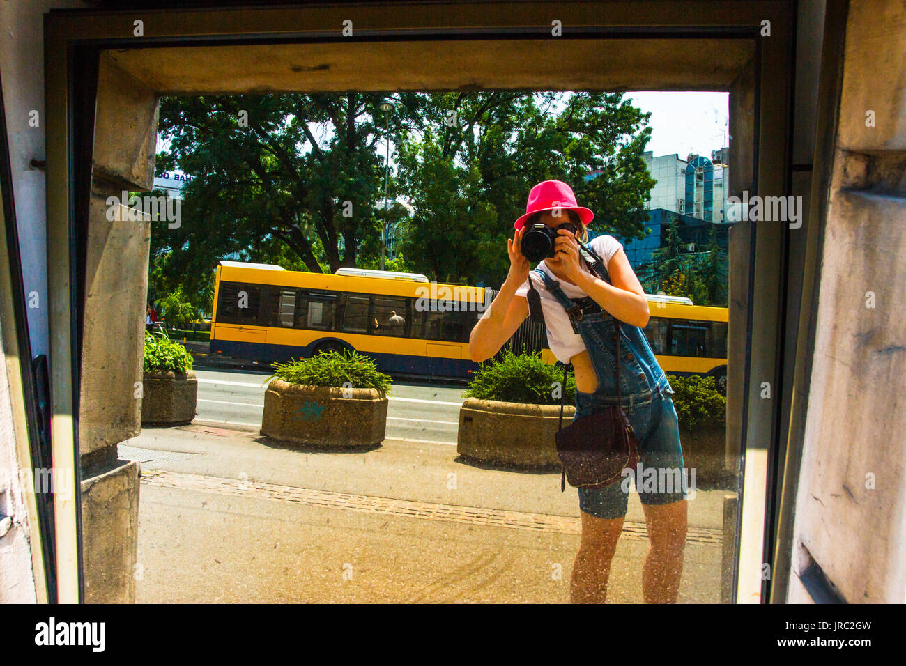 Jolie fille Prendre une photo avec un bus dans un Mirrow à Belgrade Serbie Banque D'Images