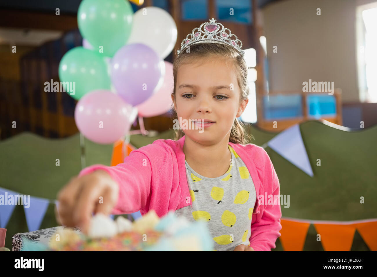 Anniversaire girl eating cake at home Banque D'Images