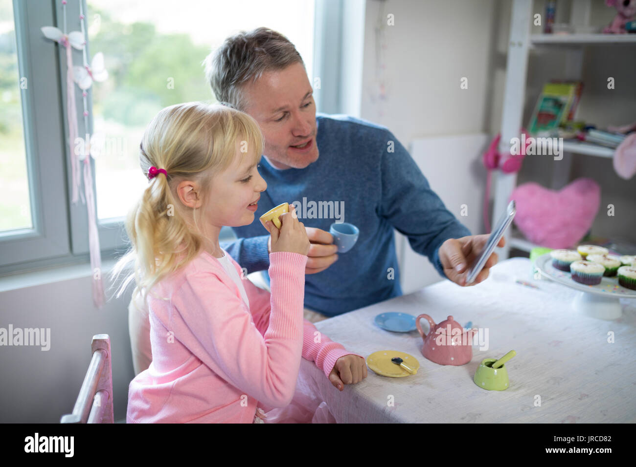Jeune fille enjouée et père de prendre un en jouant avec un selfies toy Set de cuisine Banque D'Images