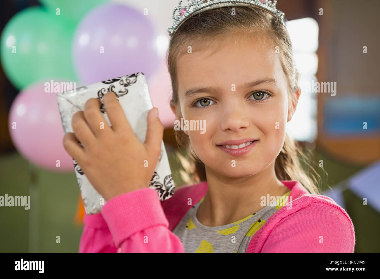 Portrait d'anniversaire girl holding une boîte-cadeau à la maison Banque D'Images