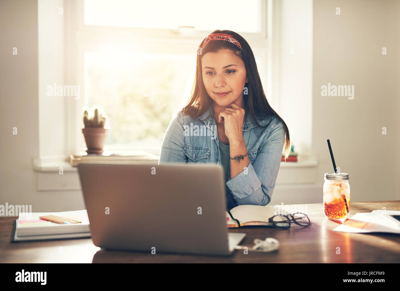 Jolie jeune femme entrepreneur using laptop sitting sur le lieu de travail en bureau. Banque D'Images