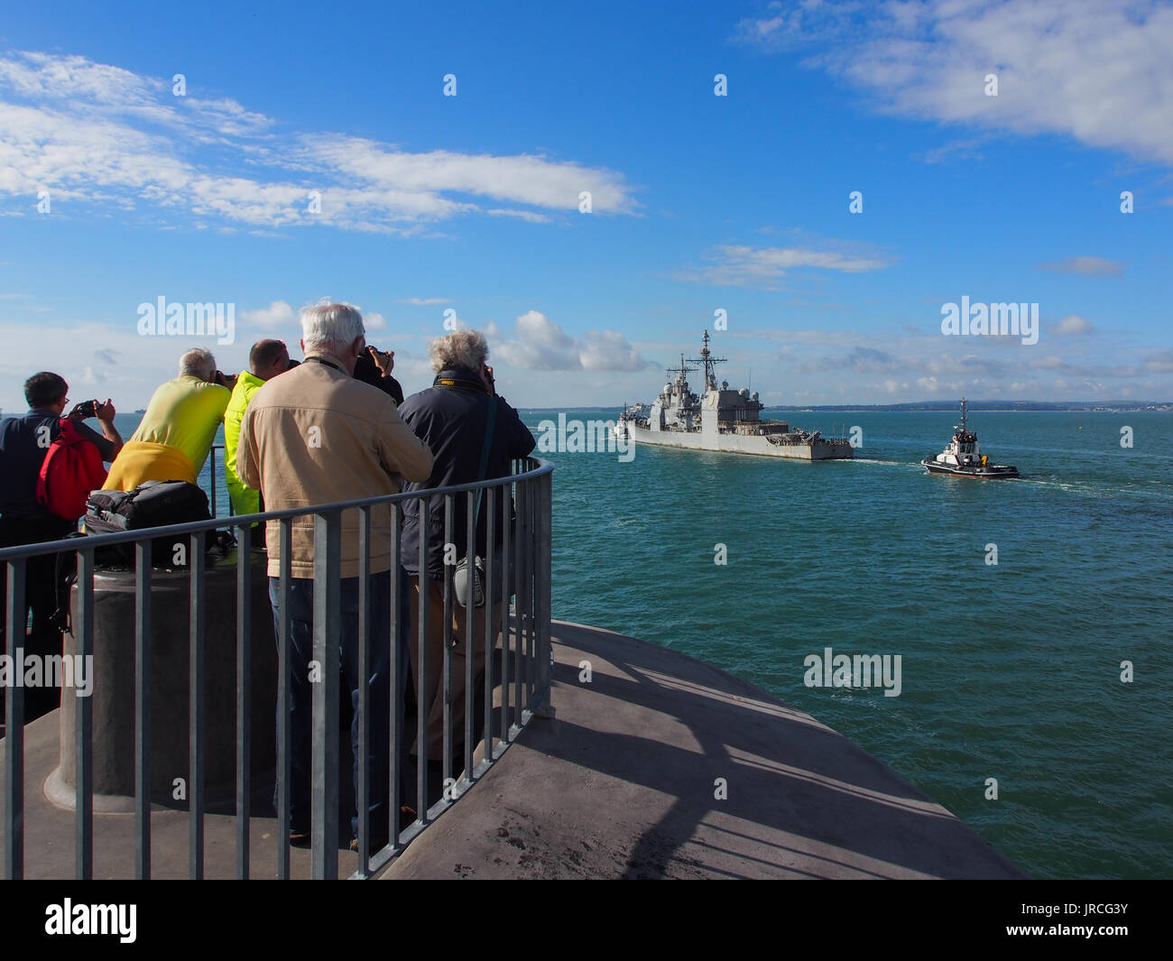 Rassembler des photographes sur le haut de la tour ronde à l'entrée du port de Portsmouth pour photographier USS mer des Philippines (CG-58) de quitter le port. Banque D'Images