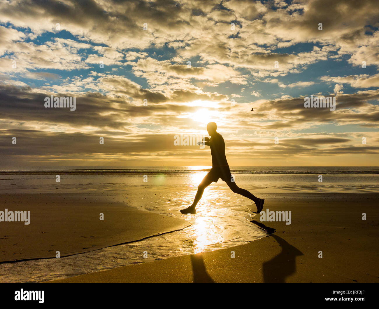 Seaton Carew, North East England, UK, 5 août 2017. Météo France : un jogger au lever du soleil sur la plage de Seaton Carew sur un glorieux samedi sur la côte nord-est. Credit : ALAN DAWSON/Alamy Live News Banque D'Images