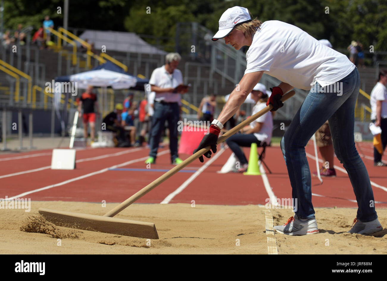 Ulm, Allemagne. Le 05 août, 2017. Heike Drechsler ratisse le sable dans la fosse de saut en longueur au cours de la jeunesse allemande d'athlétisme au Stade du Danube (Donau) à Ulm, Allemagne, 05 août 2017. L'ancien athlète de haut niveau a exécuté sa première grande performance comme arbitre. Photo : Stefan Udry/dpa/Alamy Live News Banque D'Images