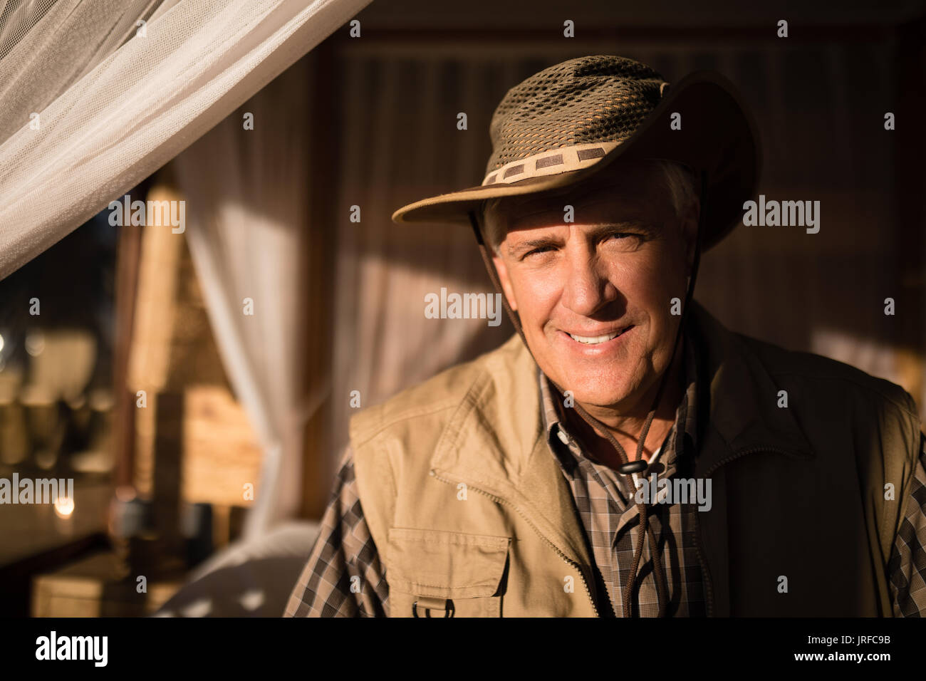 Portrait of smiling man sitting on lit à baldaquin Banque D'Images