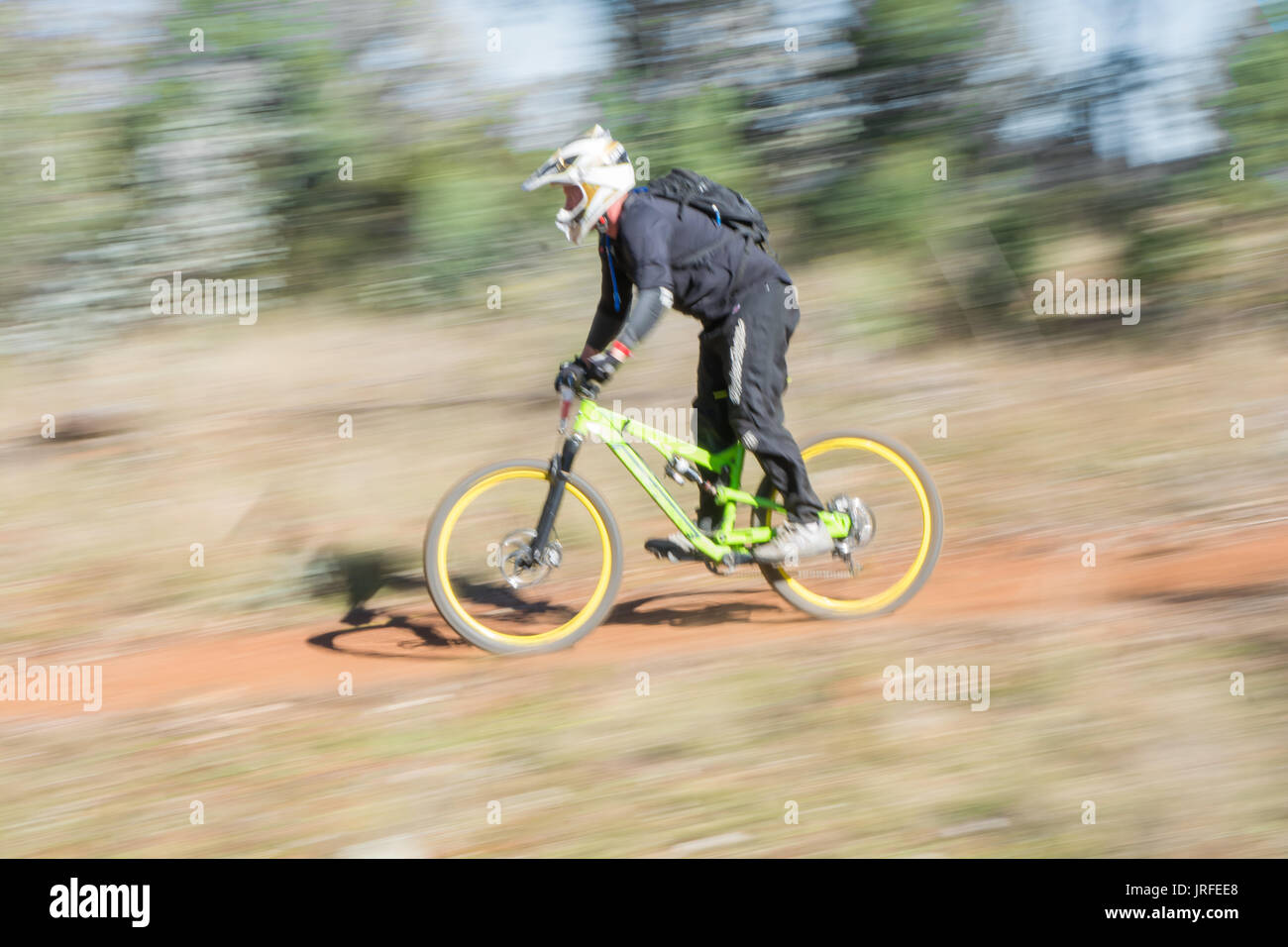 Course de vélo de montagne en accélérant vers le bas une pente graduelle à Mount Borah NSW Australie. Banque D'Images