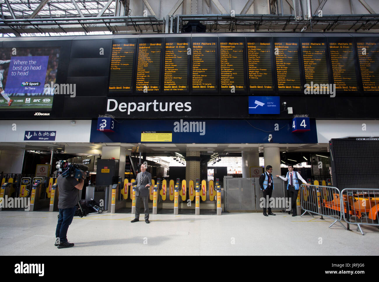 Le personnel ferroviaire sur un journaliste de télévision est-ce qu'un morceau à l'appareil photo que l'ingénierie travail commence à la gare de Waterloo à Londres, avec des services vers et depuis la gare étant significativement perturbé jusqu'au 28 août. Banque D'Images