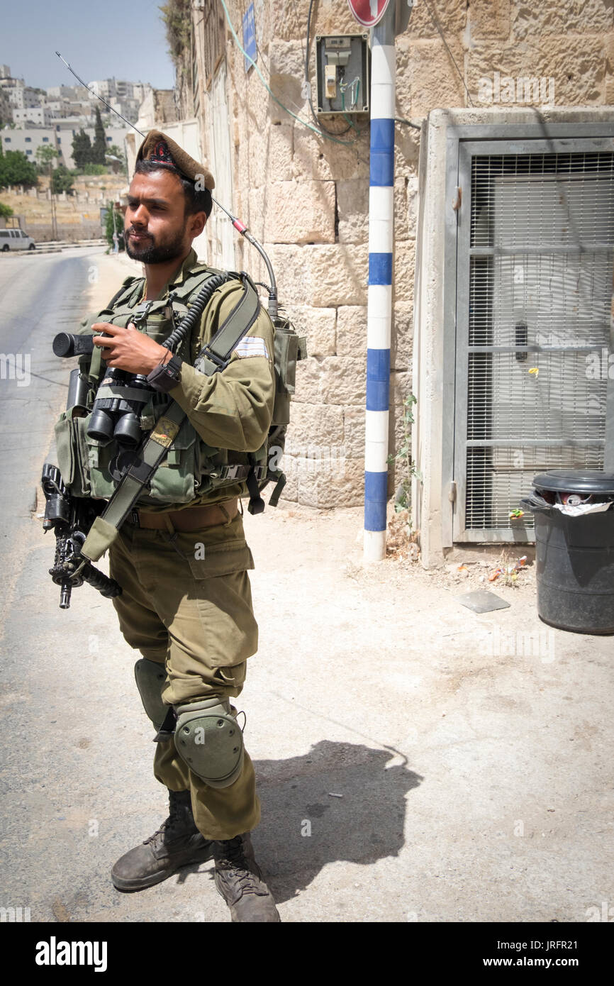 Gardant un ancien soldat israélien bustiling marché d'Hébron street maintenant fermé aux Palestiniens en raison de l'accaparement des terres de 850 colons israéliens à proximité Banque D'Images