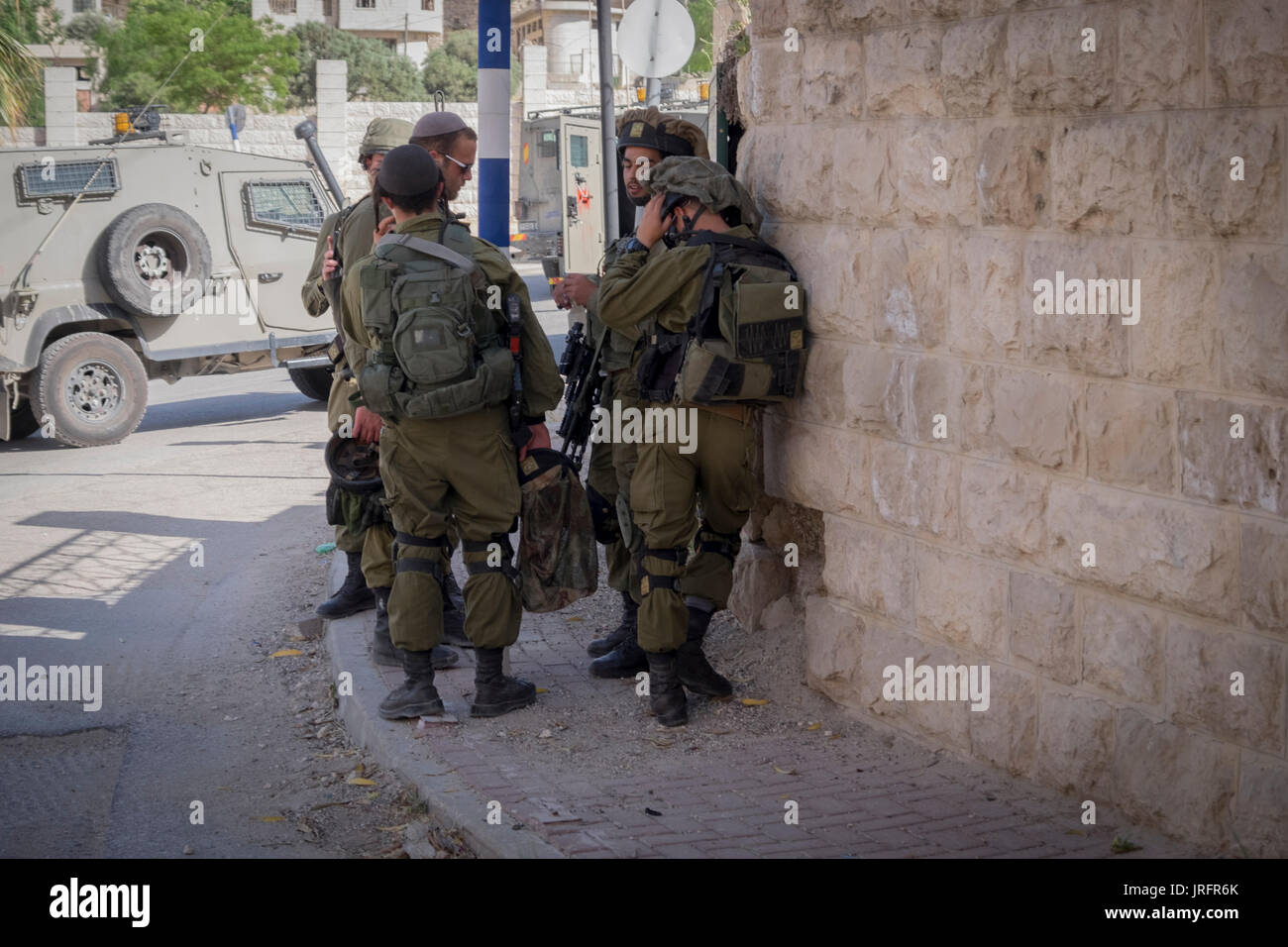 Une patrouille militaire israélienne marque une pause au cours d'une opération de surveillance à Hébron, en Cisjordanie, territoires occupés de Palestine Banque D'Images