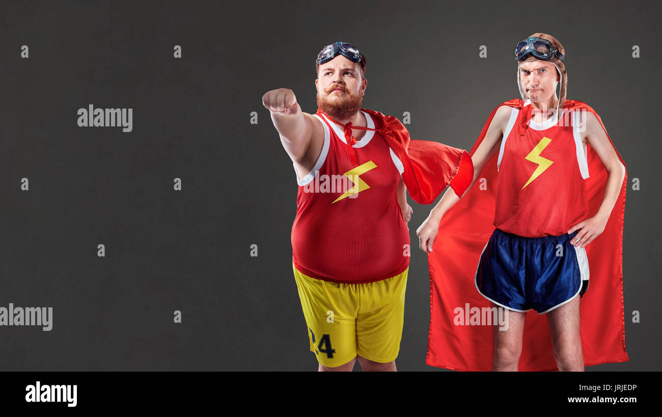 Deux drôles d'hommes en costumes de super-héros. Les personnes minces et de graisses Banque D'Images