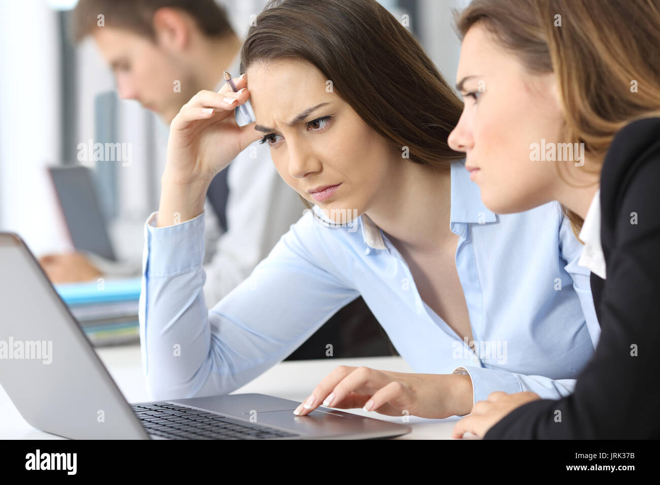 Deux inquiets businesswomen working on line avec un laptop at office Banque D'Images