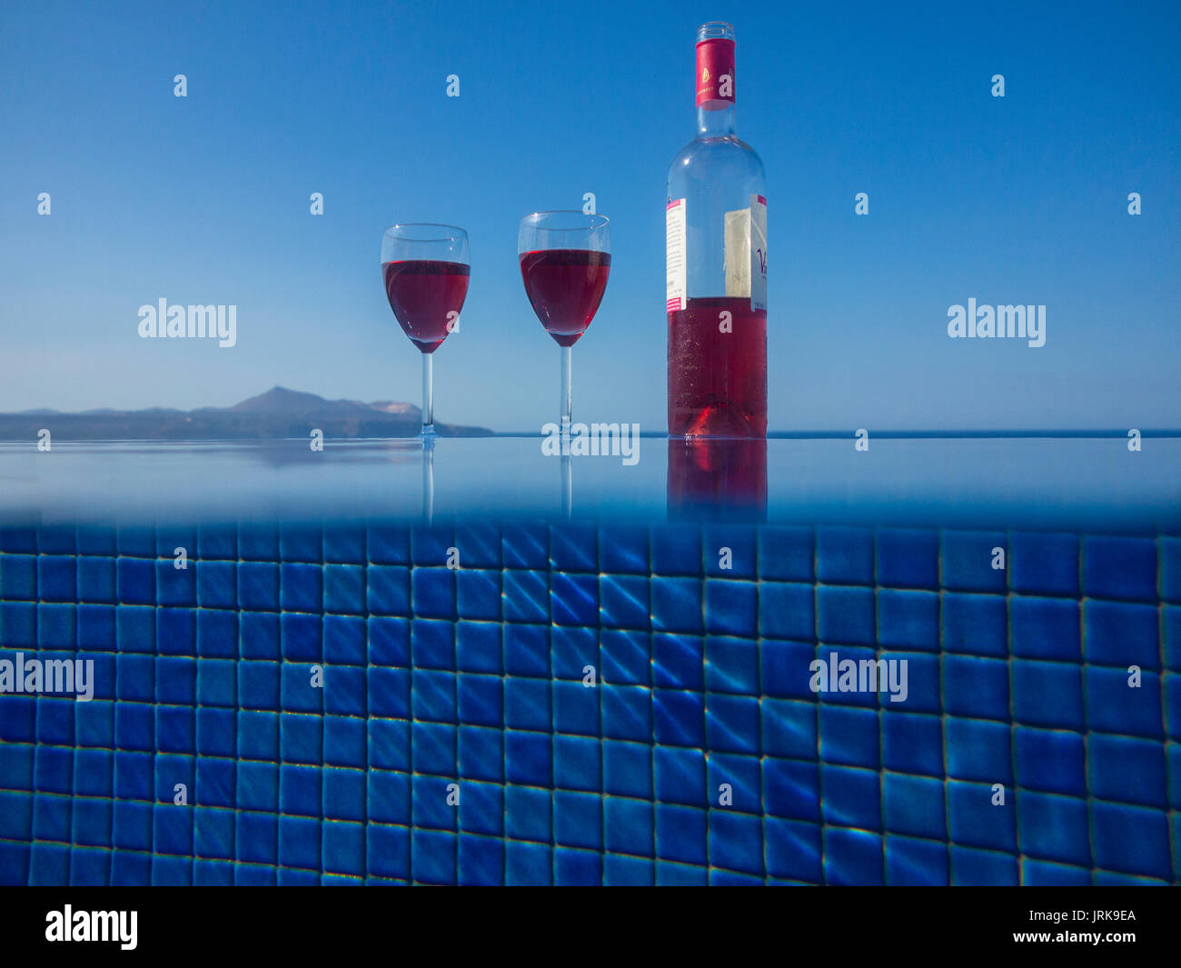 Deux verres et une bouteille de vin par un poolinfinity à débordement Banque D'Images