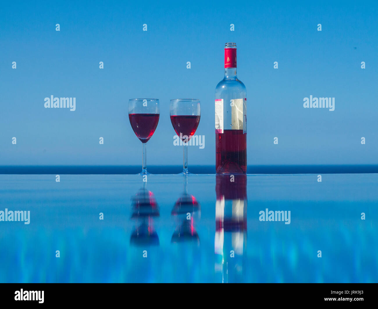 Deux verres et une bouteille de vin par un poolinfinity à débordement Banque D'Images