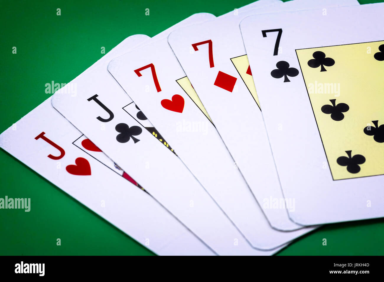 Appel de main de poker full house, composé par deux j et trois lettres du  nombre sept sur fond vert Photo Stock - Alamy