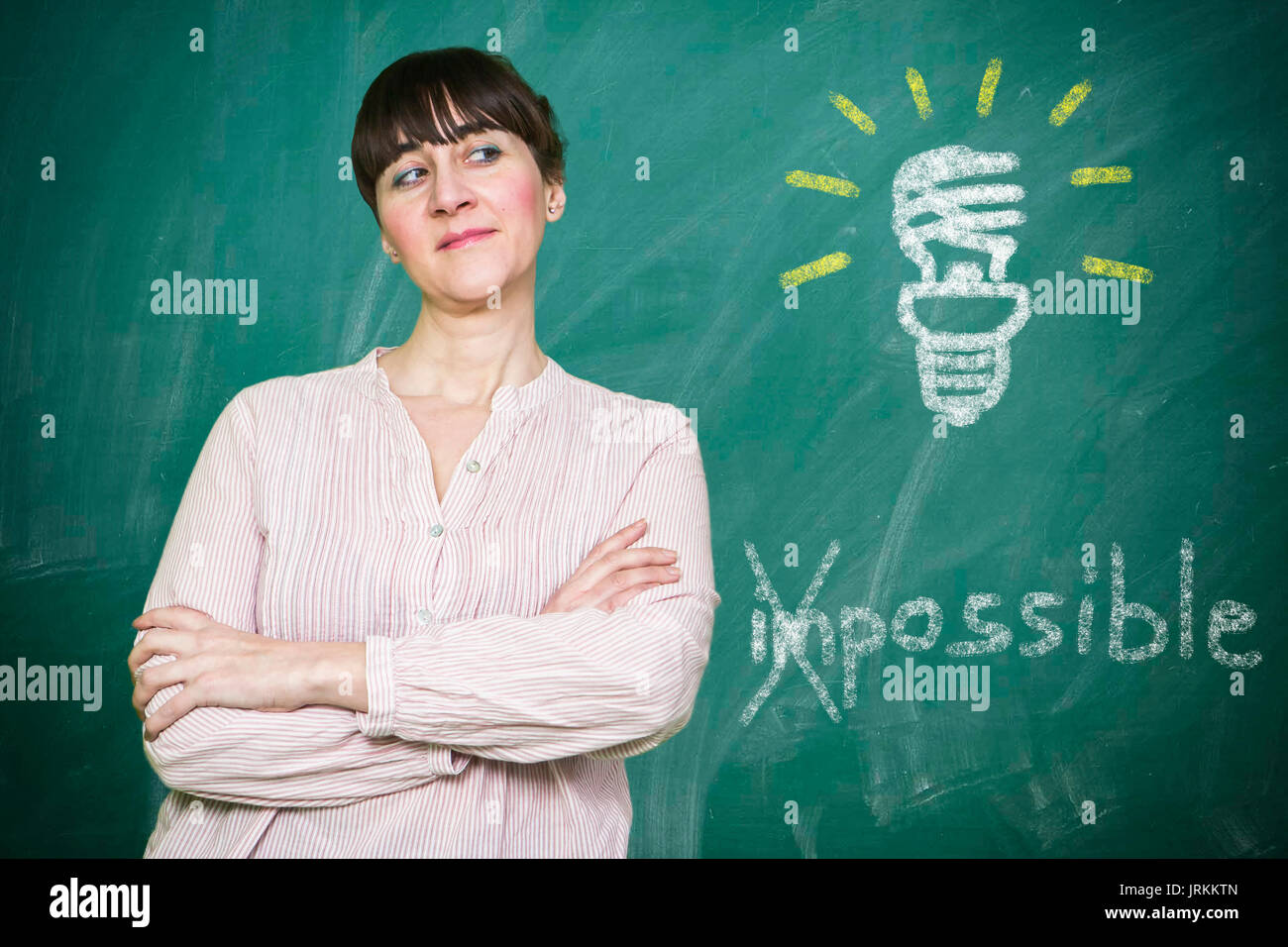 Femme sourit écrit sur un tableau noir, le concept de l'économie d'énergie est possible Banque D'Images