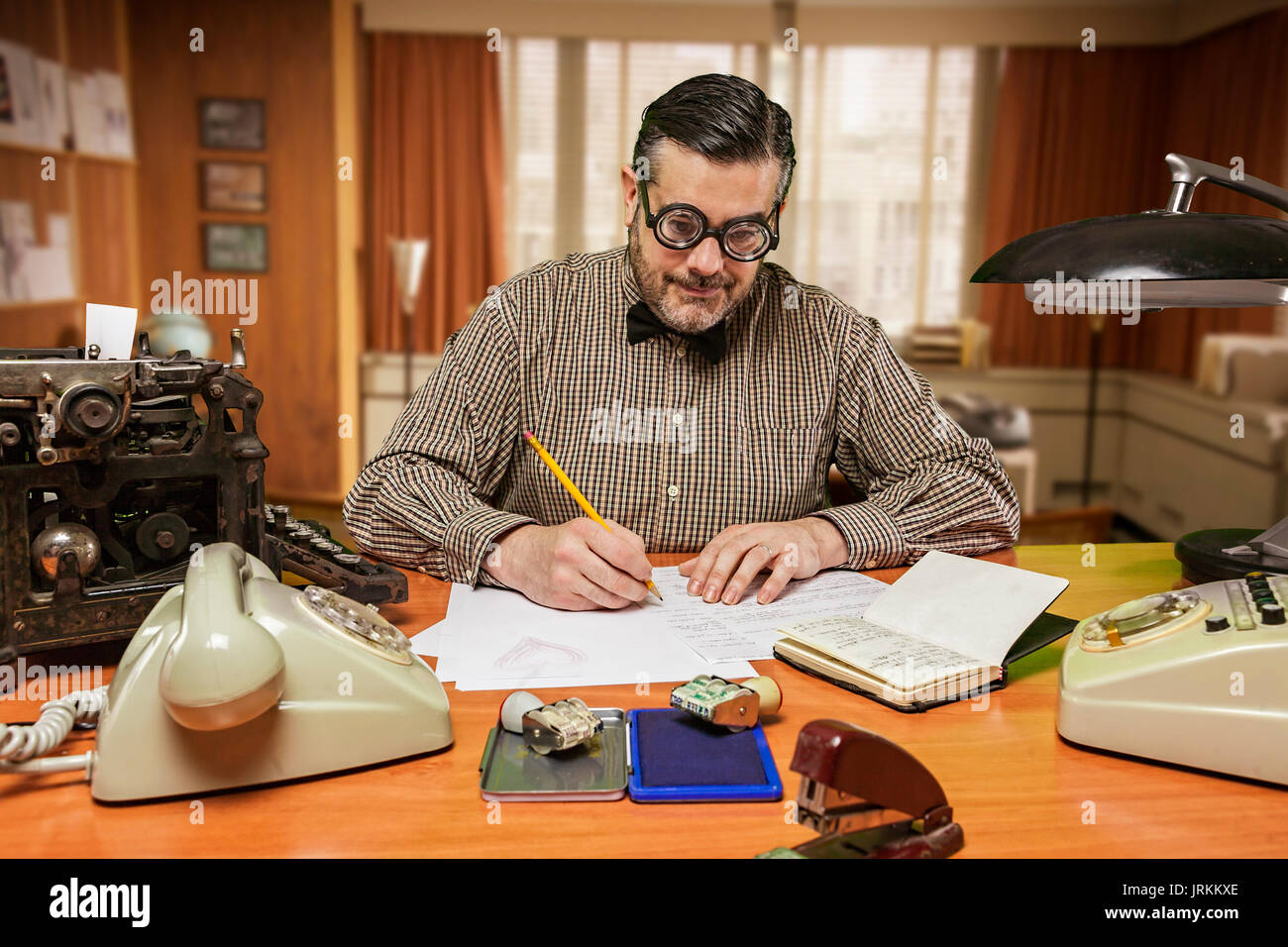 Employé avec des lunettes sur votre bureau de travail dans les années 1960 Banque D'Images