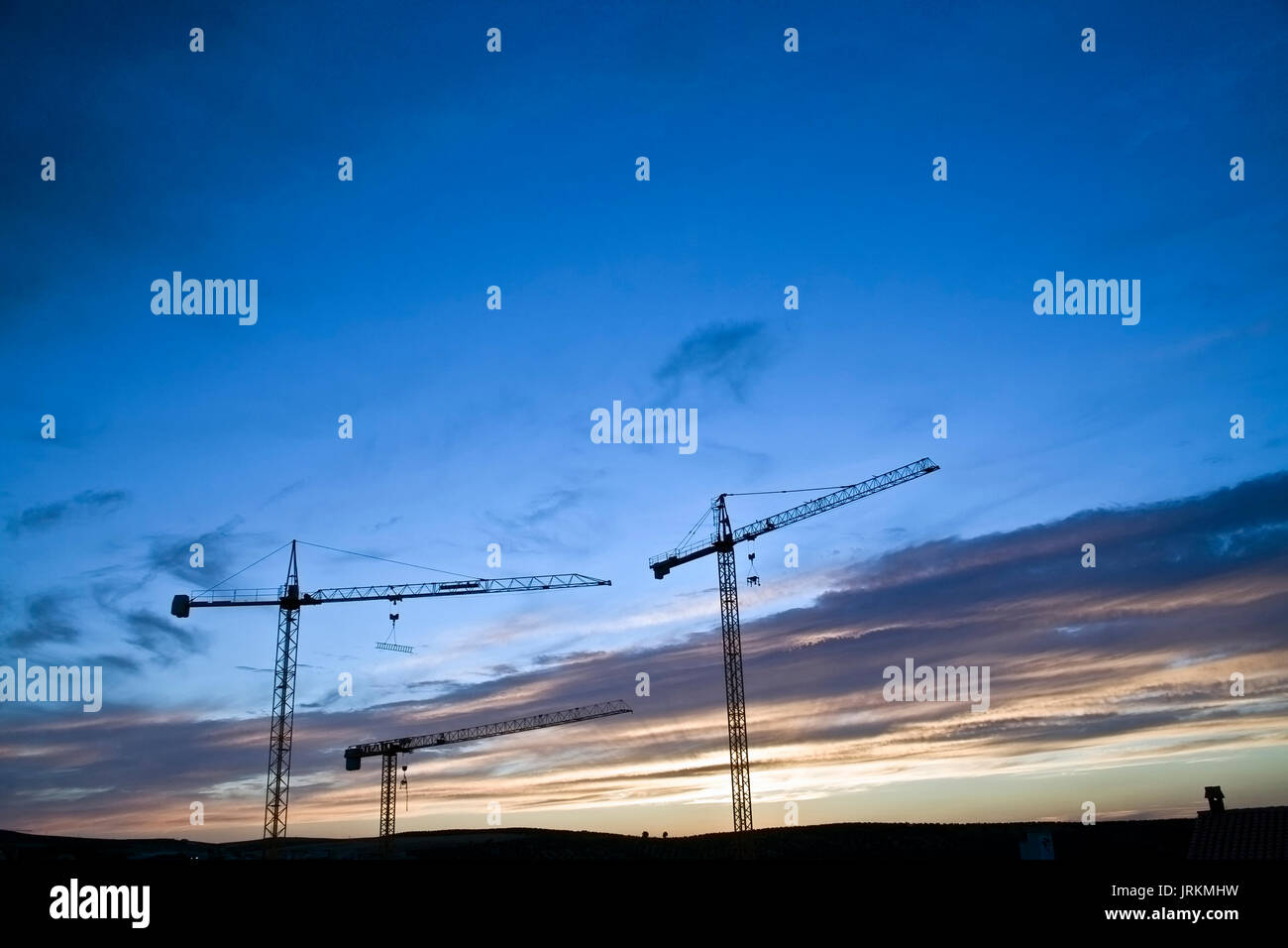 Plusieurs grues abandonnées sur le coucher du soleil dans une construction de bâtiments, l'Espagne Banque D'Images