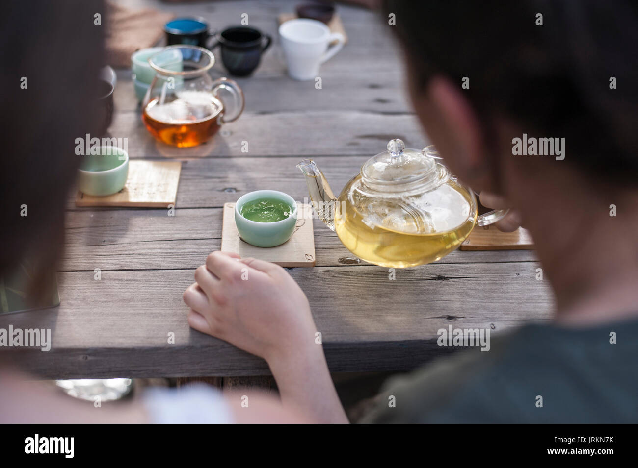 La cérémonie du thé Chinois traditionnel - woman holding glass tea pot verser en tasse de thé vert chinois Banque D'Images