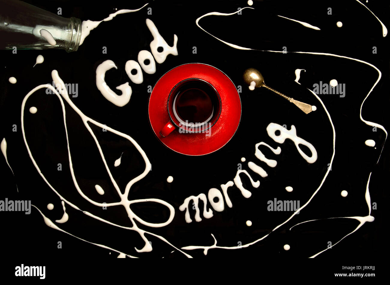 Tasse de café rouge sur fond noir et 'Bonjour !' écrit avec du lait Banque D'Images