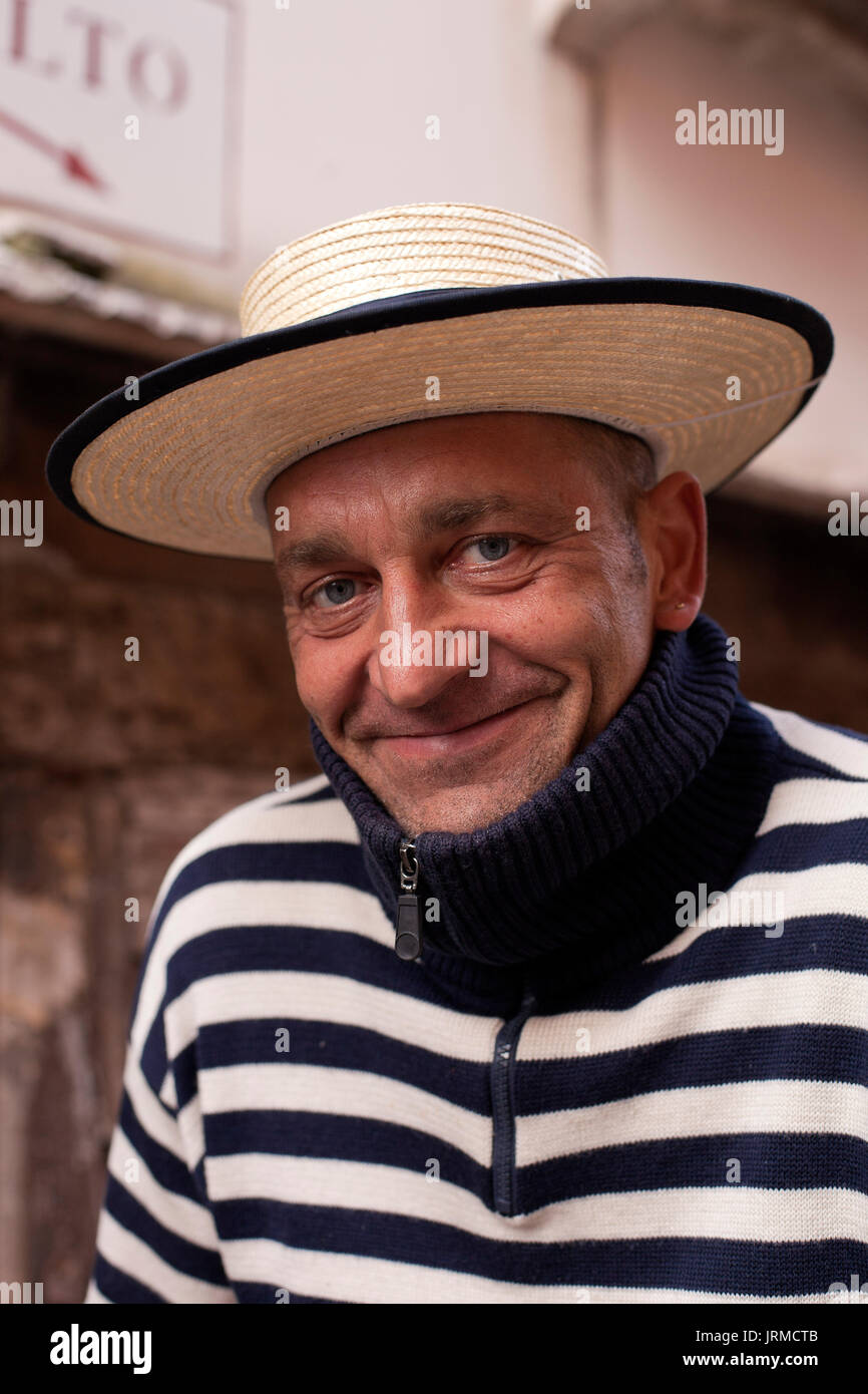 A smiling gondolier détend sur un pont près du Rialto de Venise, Italie Banque D'Images