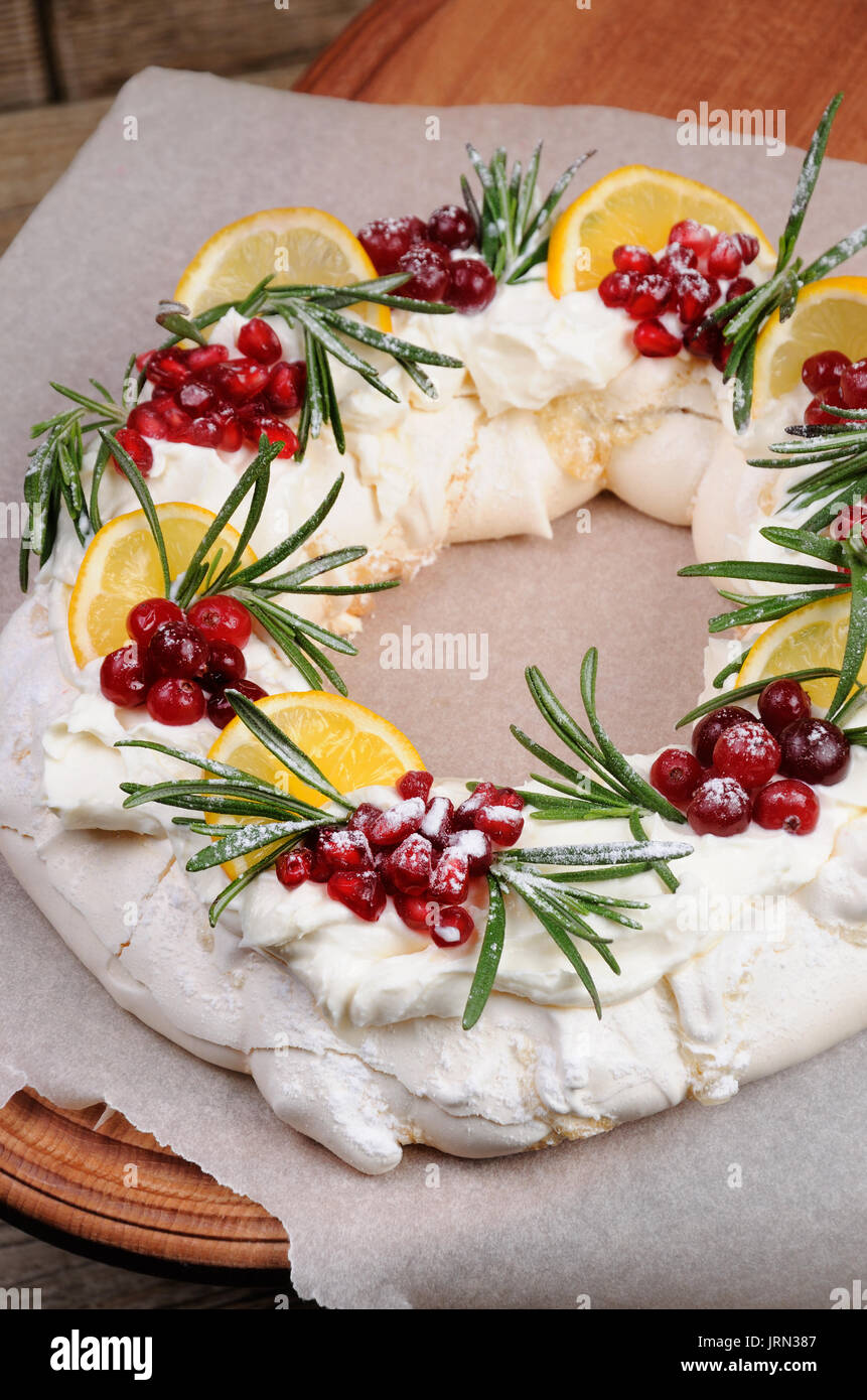 Pavlova Gateau A La Forme D Une Couronne De Noel De Meringue Avec Creme Grenade Canneberge Brins De Romarin Photo Stock Alamy