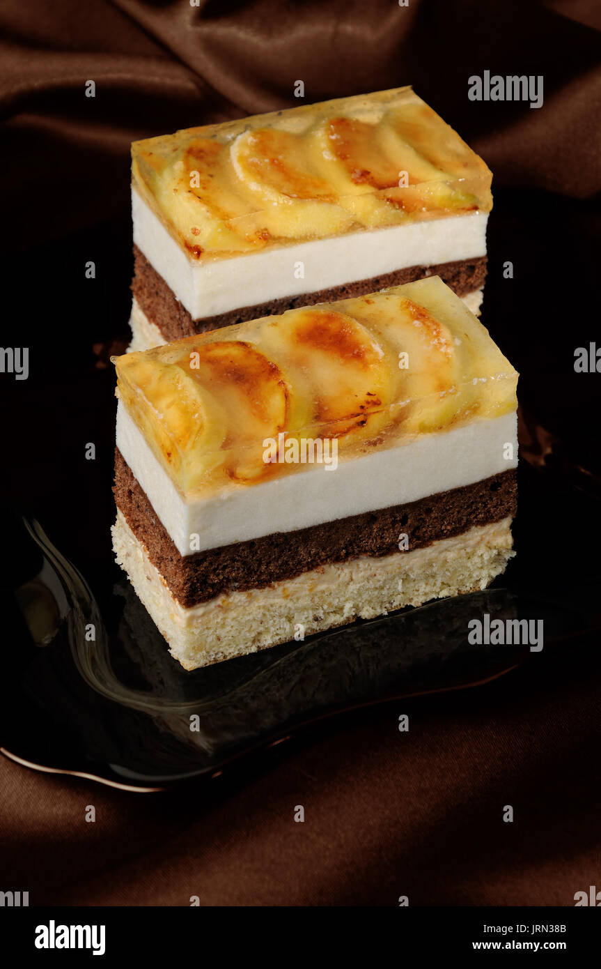 Empilées de gâteau au caramel, chocolat, mousse de pomme et amande biscuit avec une couche de gelée de pommes caramélisées tranches Banque D'Images