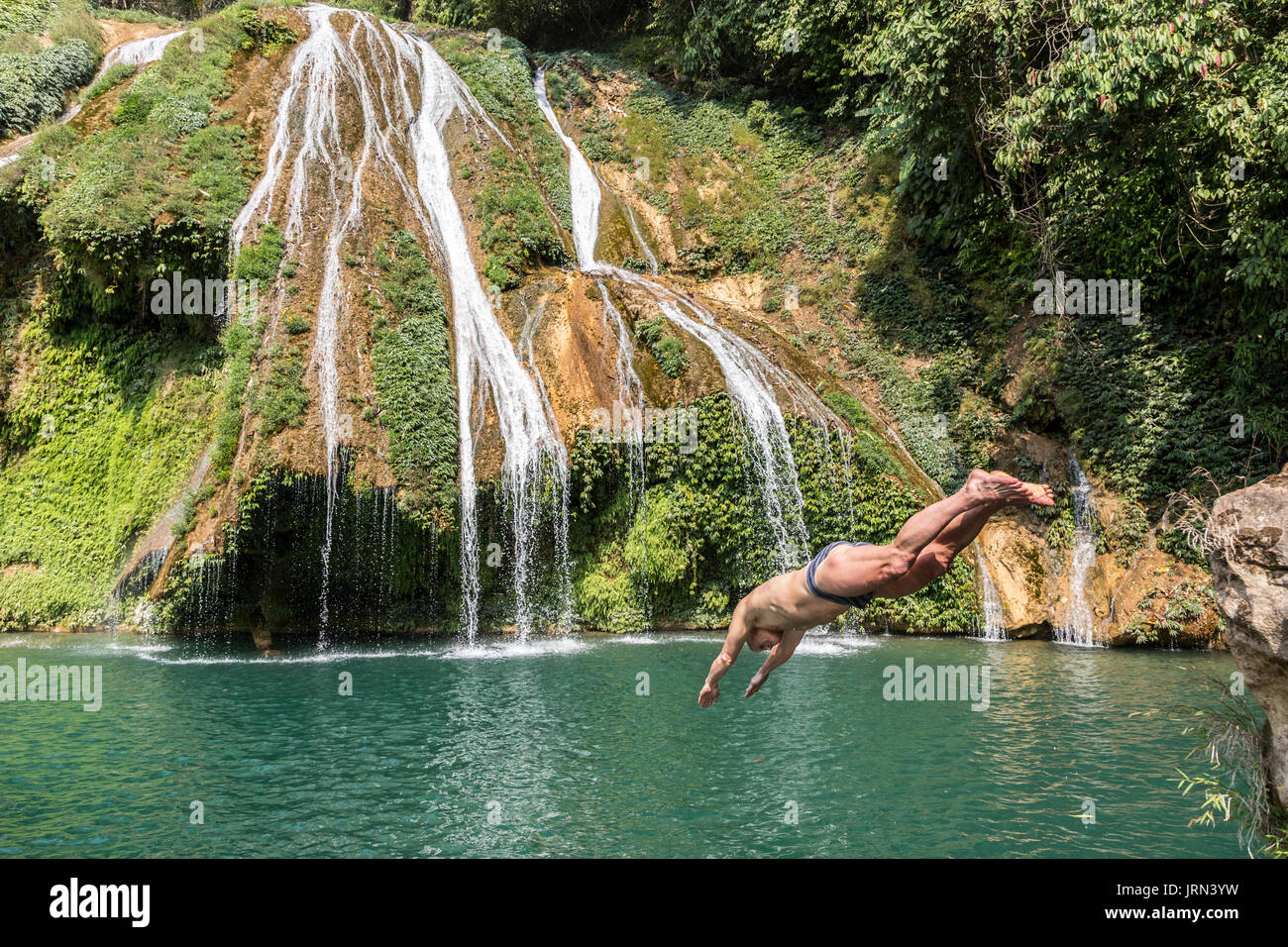 L'homme de plonger dans une piscine à la base d'une chute dans une région éloignée du Meghalaya, en Inde Banque D'Images