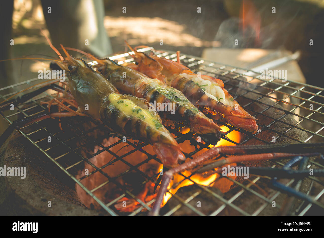 Crevettes grillées avec du beurre et de la rivière d'herbe sur flaming grill Banque D'Images