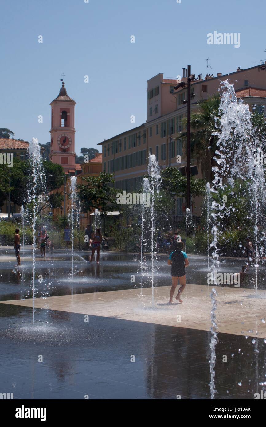 Enfants qui barbotent dans des fontaines à Massena Square, Nice, France Banque D'Images