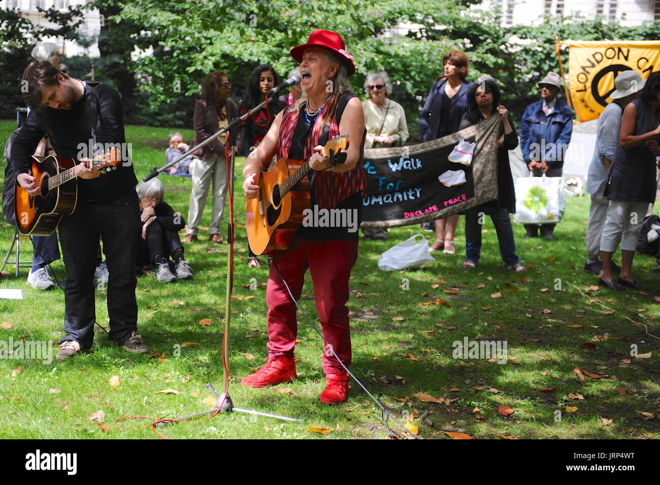 Londres, Royaume-Uni. Le 06 août, 2017. Peter Dunne (chanteuse folk) le chant à la campagne pour le désarmement nucléaire de la commémoration annuelle du bombardement atomique de Hiroshima, Japon à Tavistock Square, Londres, Royaume-Uni. Le 6 août 1967 un cerisier a été planté dans le square par Camden Council à la mémoire des victimes de l'attentat. Depuis lors, une cérémonie annuelle a eu lieu autour de l'arbre de se souvenir de l'attaque. Crédit : Michael Preston/Alamy Live News Banque D'Images