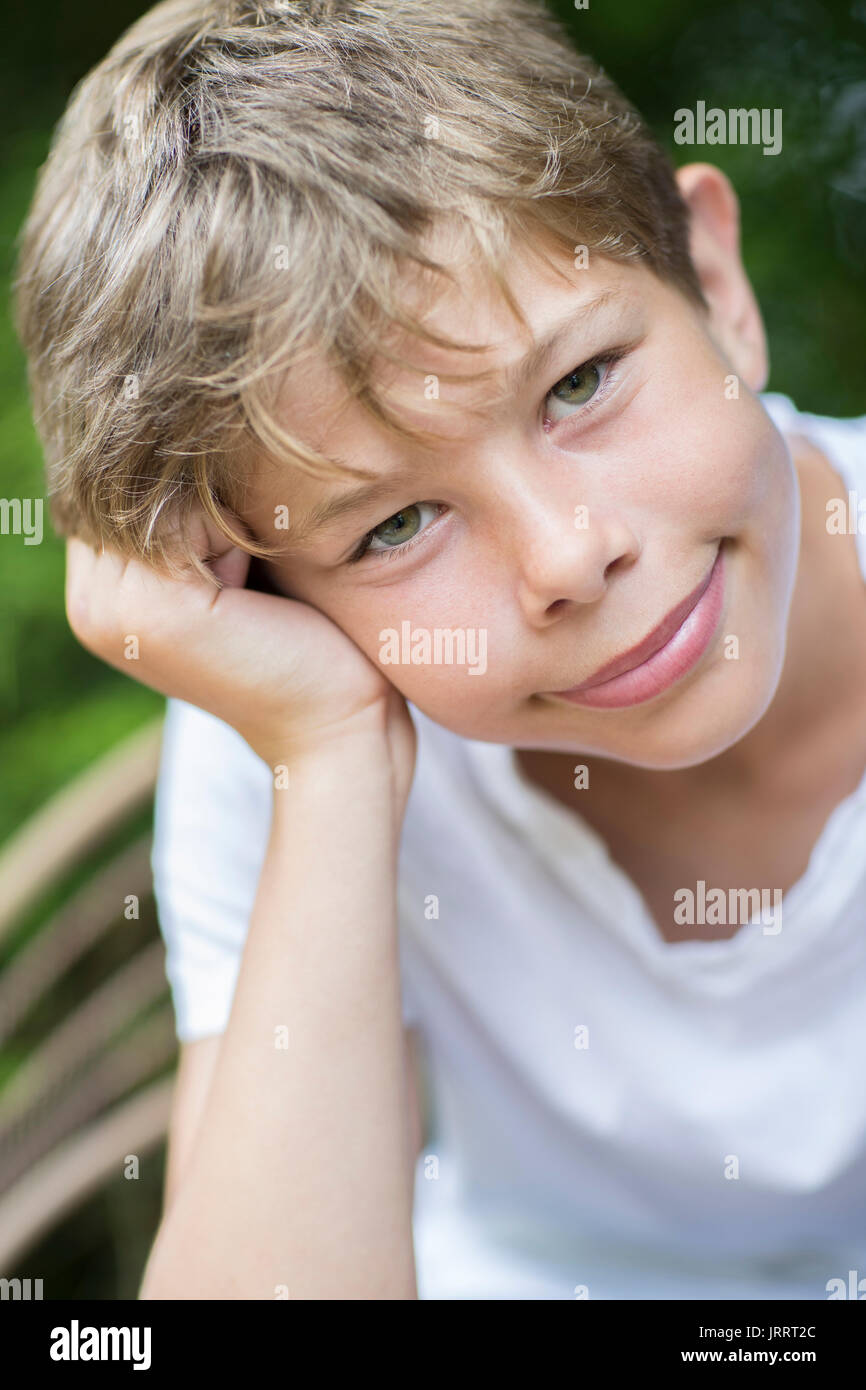 Portrait Of Happy Boy Sitting Outdoors Banque D'Images